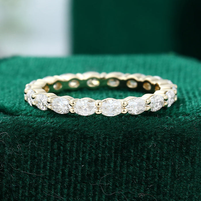Front view of an oval moissanite east west full eternity wedding band in yellow gold