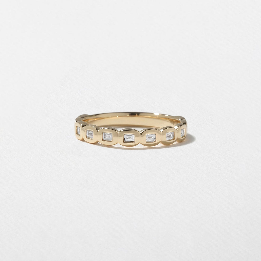 Baguette lab grown diamond bezel half eternity wedding band in yellow gold