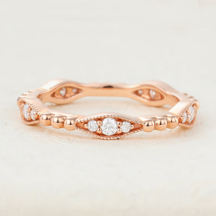 Rose gold vintage band with navette shaped stations of three round moissanite stones between beaded bars, front view