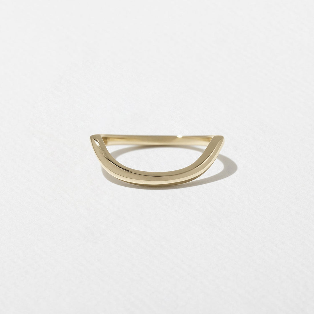 Curved plain wedding band in yellow gold front view
