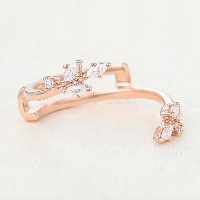 Rose gold open leaf moissanite band with marquise and round stone clusters on each end, angled view