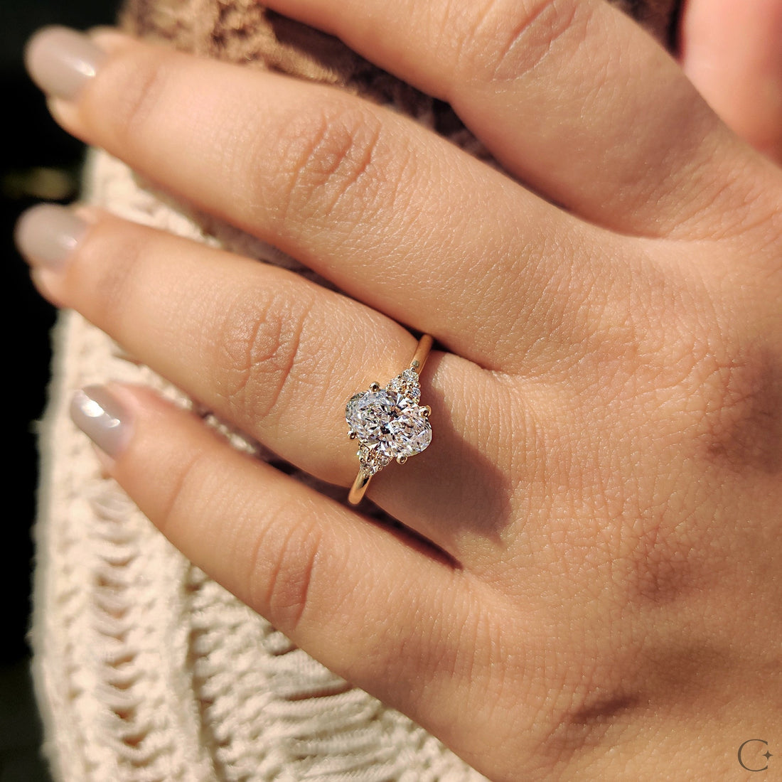 Oval cut lab grown diamond petite cluster ring worn on the hand