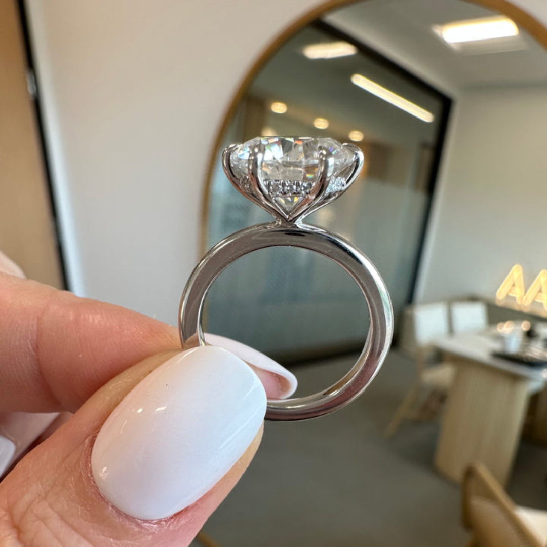 Round cut lab grown diamond ring with six claw head and hidden halo on a wide band