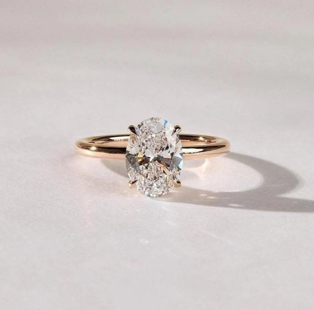 Oval cut lab grown diamond solitaire engagement ring on a plain yellow gold band