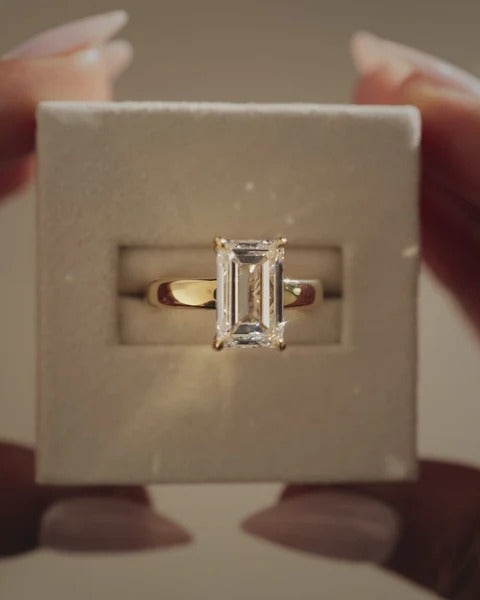 Emerald cut diamond solitaire ring with cigar band