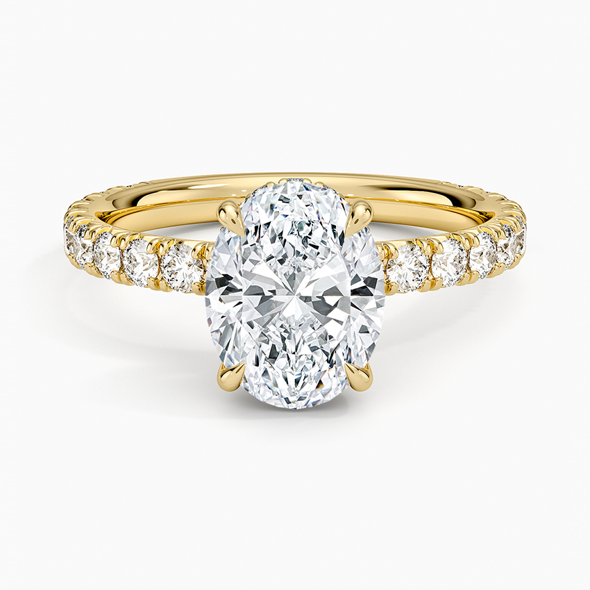 Oval cut lab grown diamond ring with a hidden halo and large stone pave in yellow gold, top view