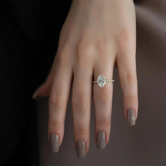 Oval cut lab grown diamond ring with scalloped shared prong band shown on the hand