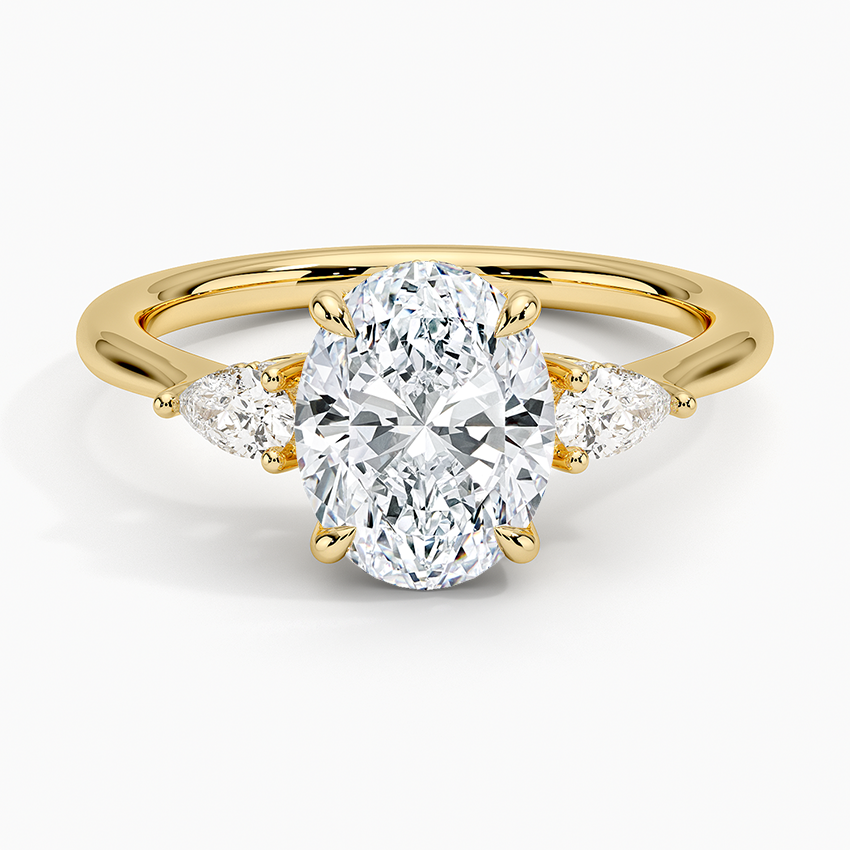 Oval cut lab grown diamond three stone ring with pear sides and hidden halo in yellow gold, top view