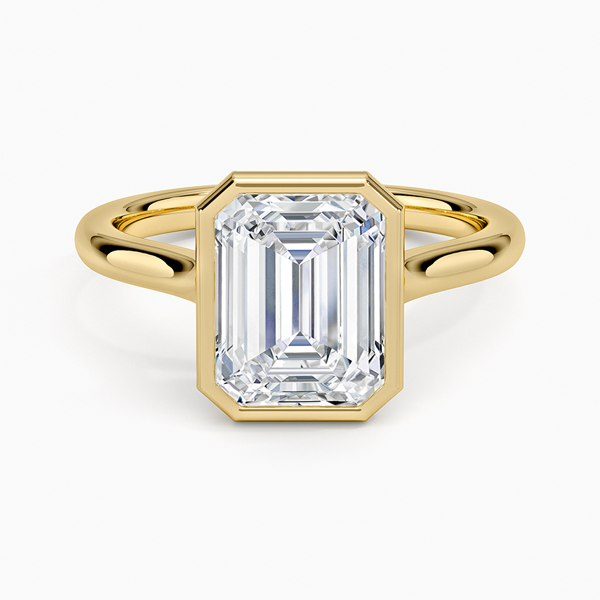 Bezel set emerald cut lab grown diamond solitaire ring in yellow gold, top view showing the full metal rim