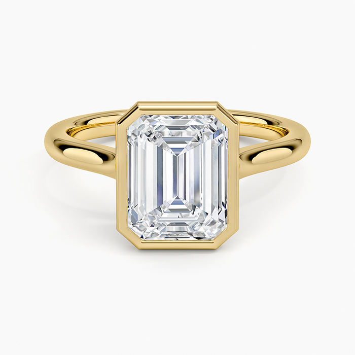 Bezel set emerald cut lab grown diamond solitaire ring in yellow gold, top view showing the full metal rim