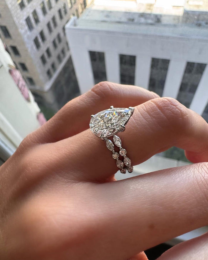 Pear cut diamond solitaire nested with the shaped chevron wedding band, worn on the hand