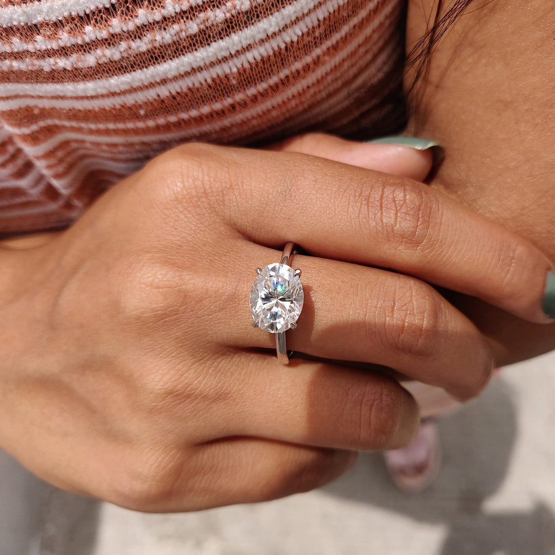 East west oval cut lab grown diamond solitaire worn on the hand