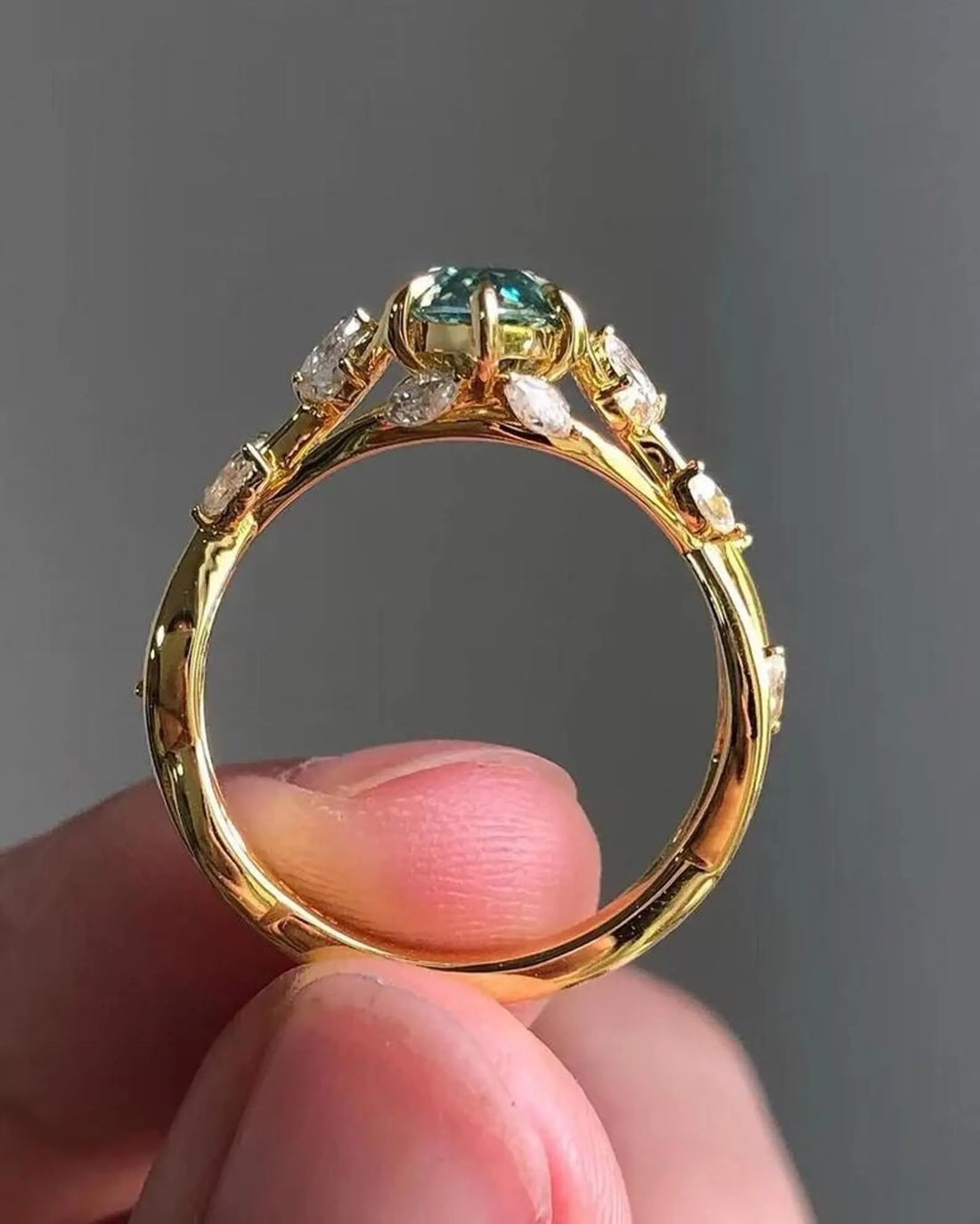 Teal moissanite engagement ring with vine and branch setting