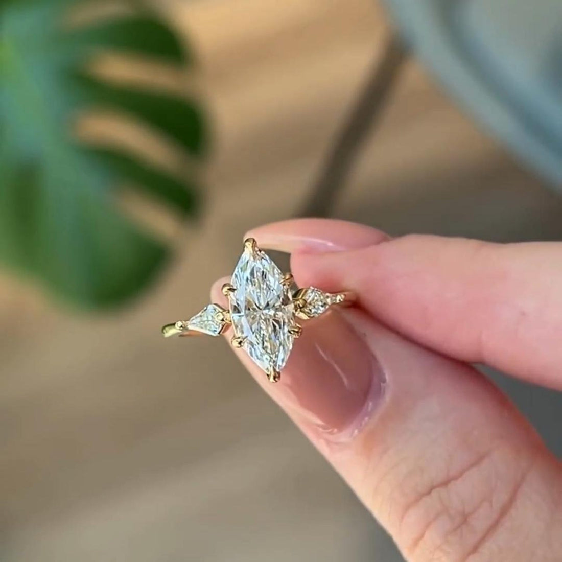 Marquise cut lab grown diamond engagement ring with kite side stones worn on hand