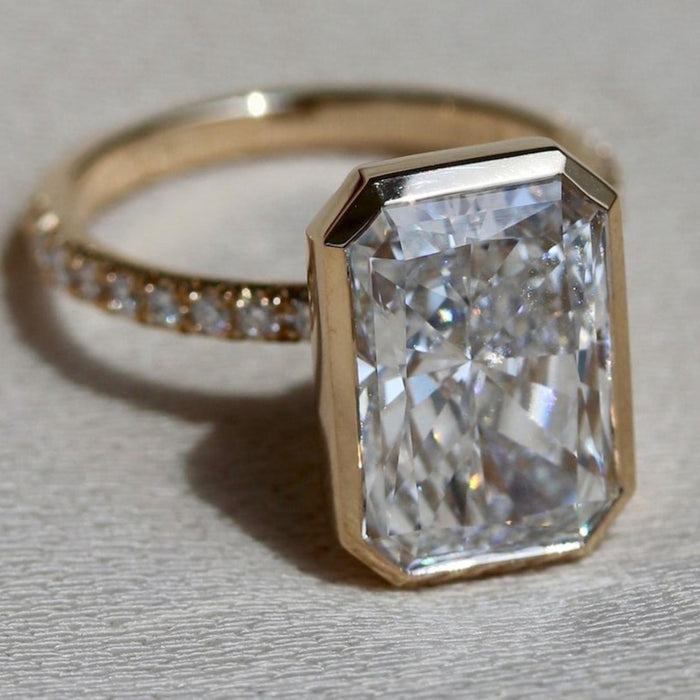 Full bezel enclosing the radiant cut lab grown diamond above a pave band