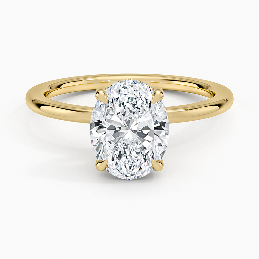 Oval cut lab grown diamond ring with a hidden halo on a round wire band in yellow gold, top view