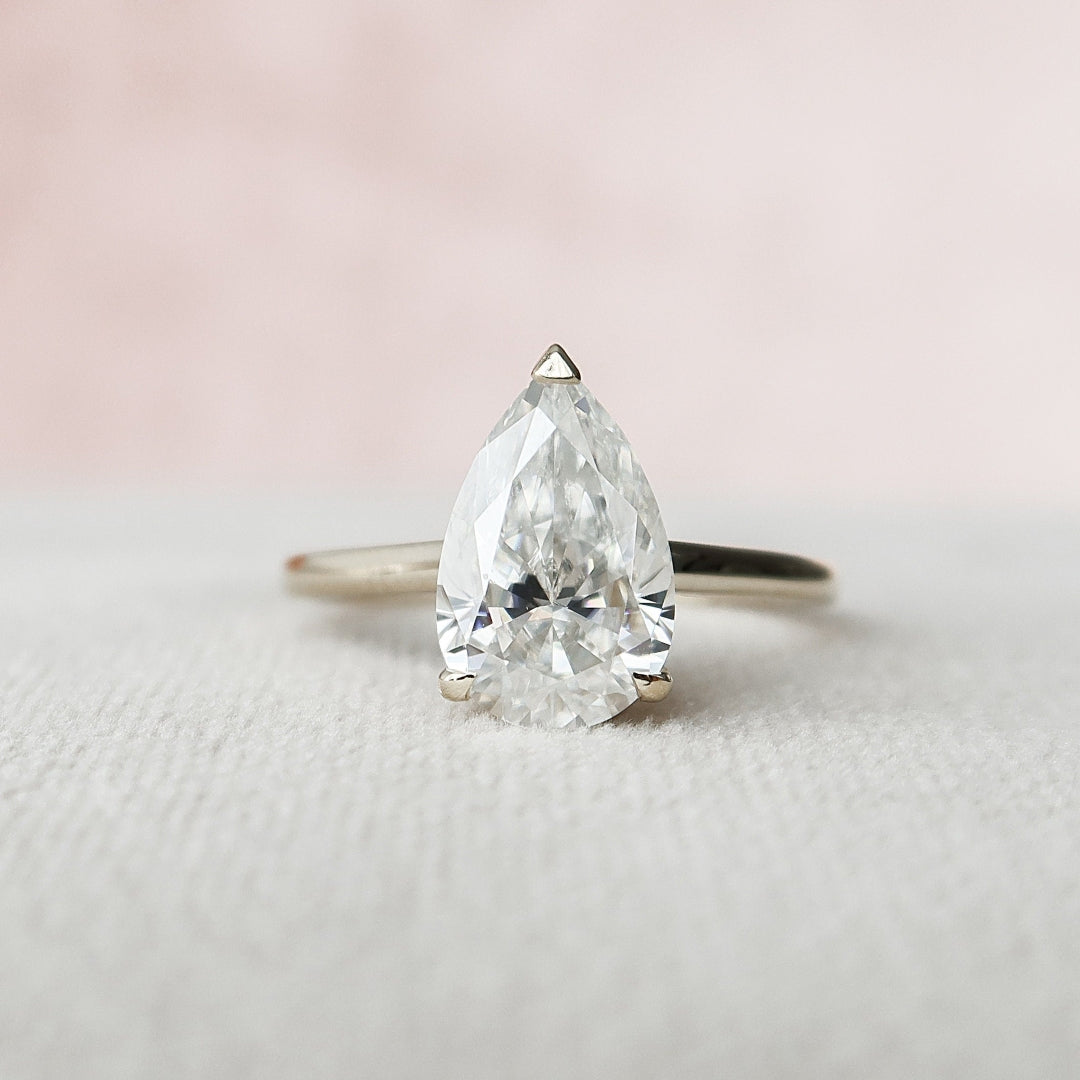 Pear cut lab grown diamond ring with hidden halo and diamond set bridge
