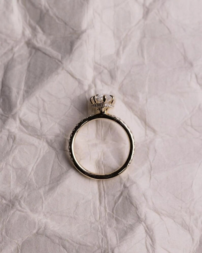Pear cut lab grown diamond pave engagement ring viewed through the band