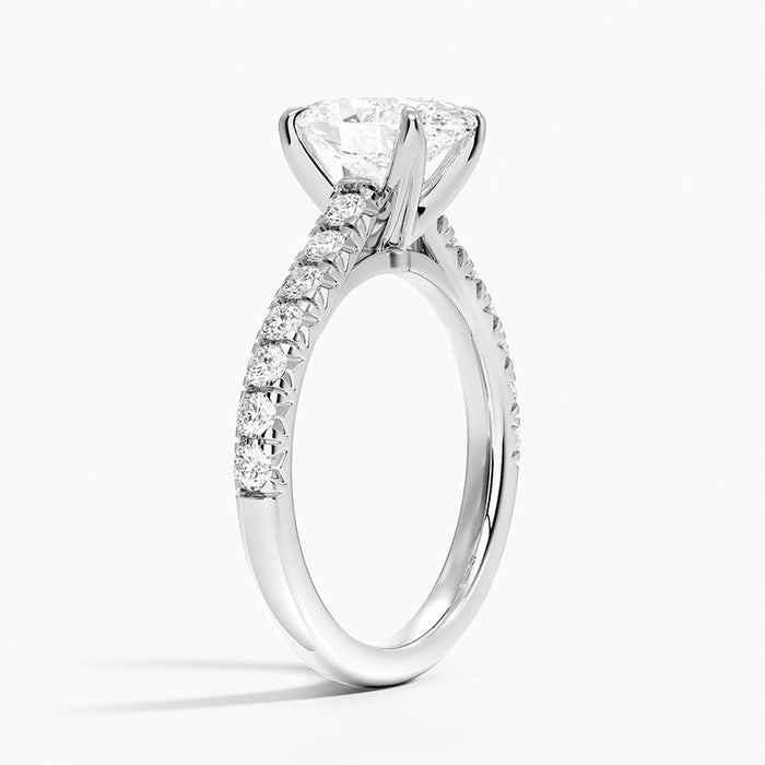 Profile view showing the claws crossing beneath the stone and the fishtail set pave shoulders