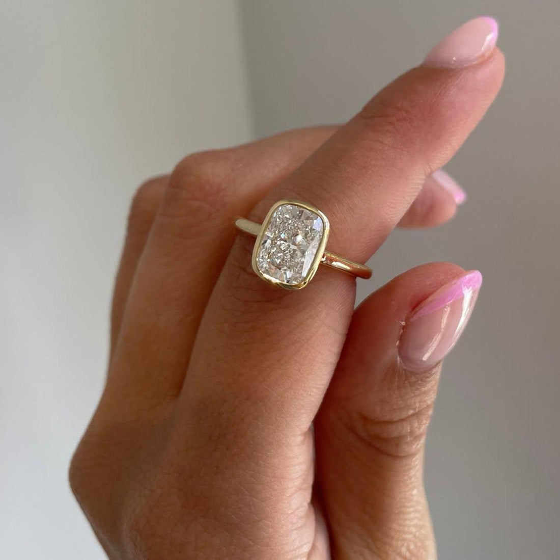Full bezel setting wrapping the girdle of the elongated cushion lab grown diamond