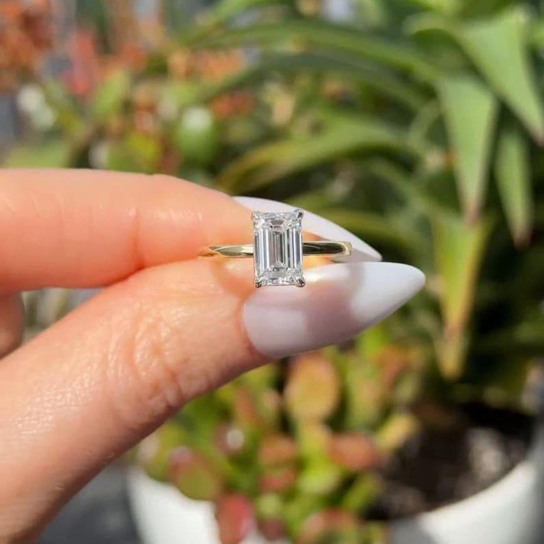 Emerald cut lab grown diamond solitaire ring with plain band in yellow gold