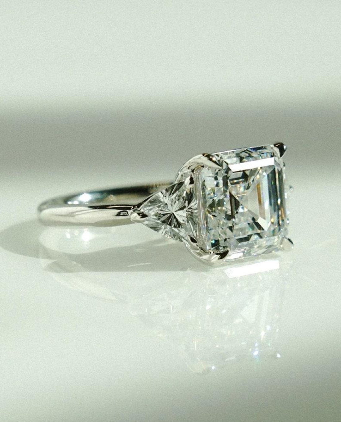 Asscher cut lab grown diamond three stone engagement ring with trillion side stones in white gold