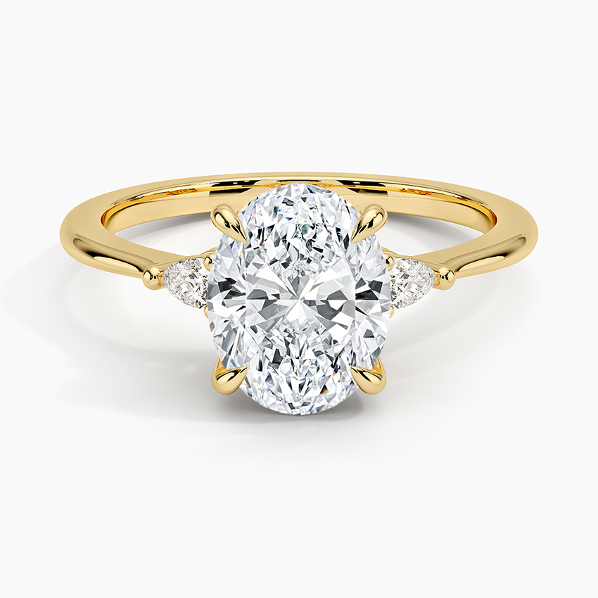 Oval cut lab grown diamond ring with petite pear and round shoulder accents in yellow gold, top view