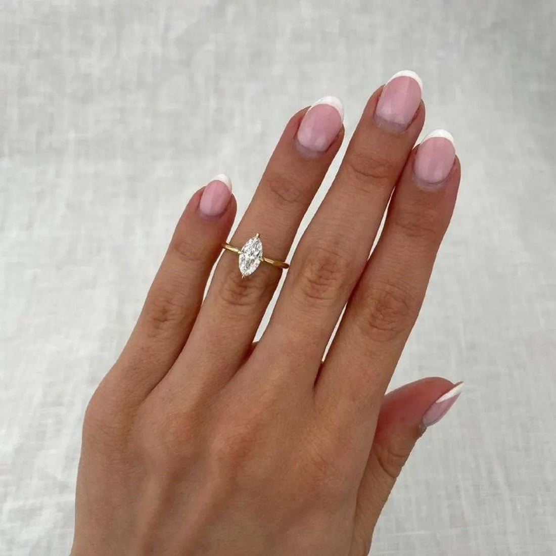 Marquise cut lab grown diamond solitaire engagement ring in yellow gold shown on the hand
