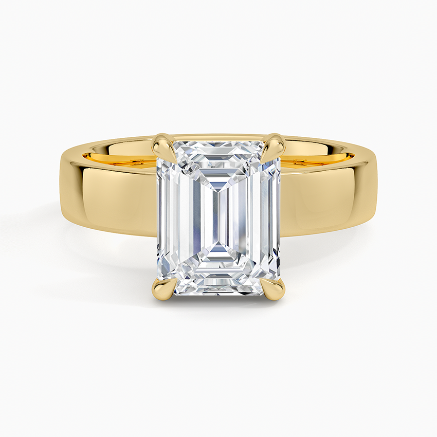Emerald cut lab grown diamond ring in yellow gold set low into a wide polished band, top view