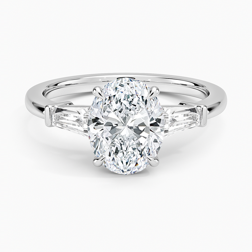 Oval cut lab grown diamond three stone ring with tapered baguette sides in white gold, top view