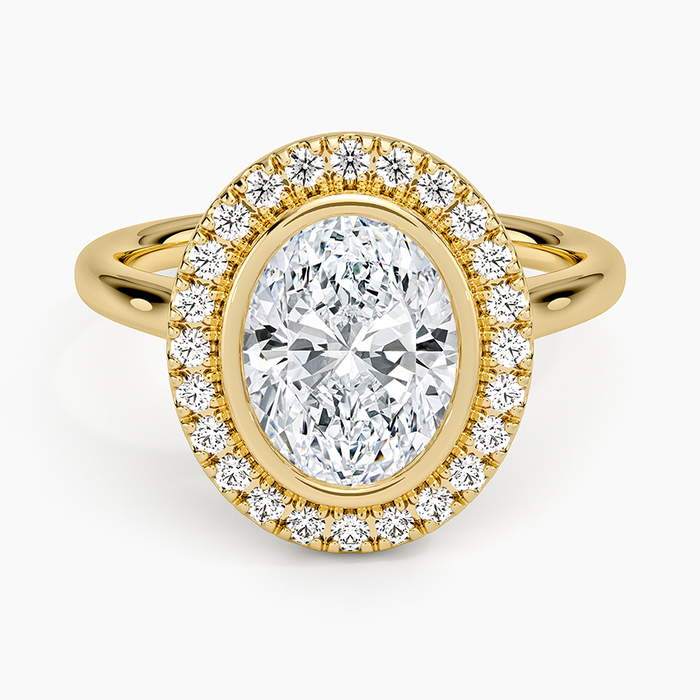 Oval cut lab grown diamond ring with a full bezel inside a pave halo in yellow gold, top view