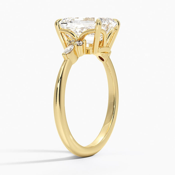 Profile view showing the slim plain band and the open arched gallery beneath the emerald cut centre stone