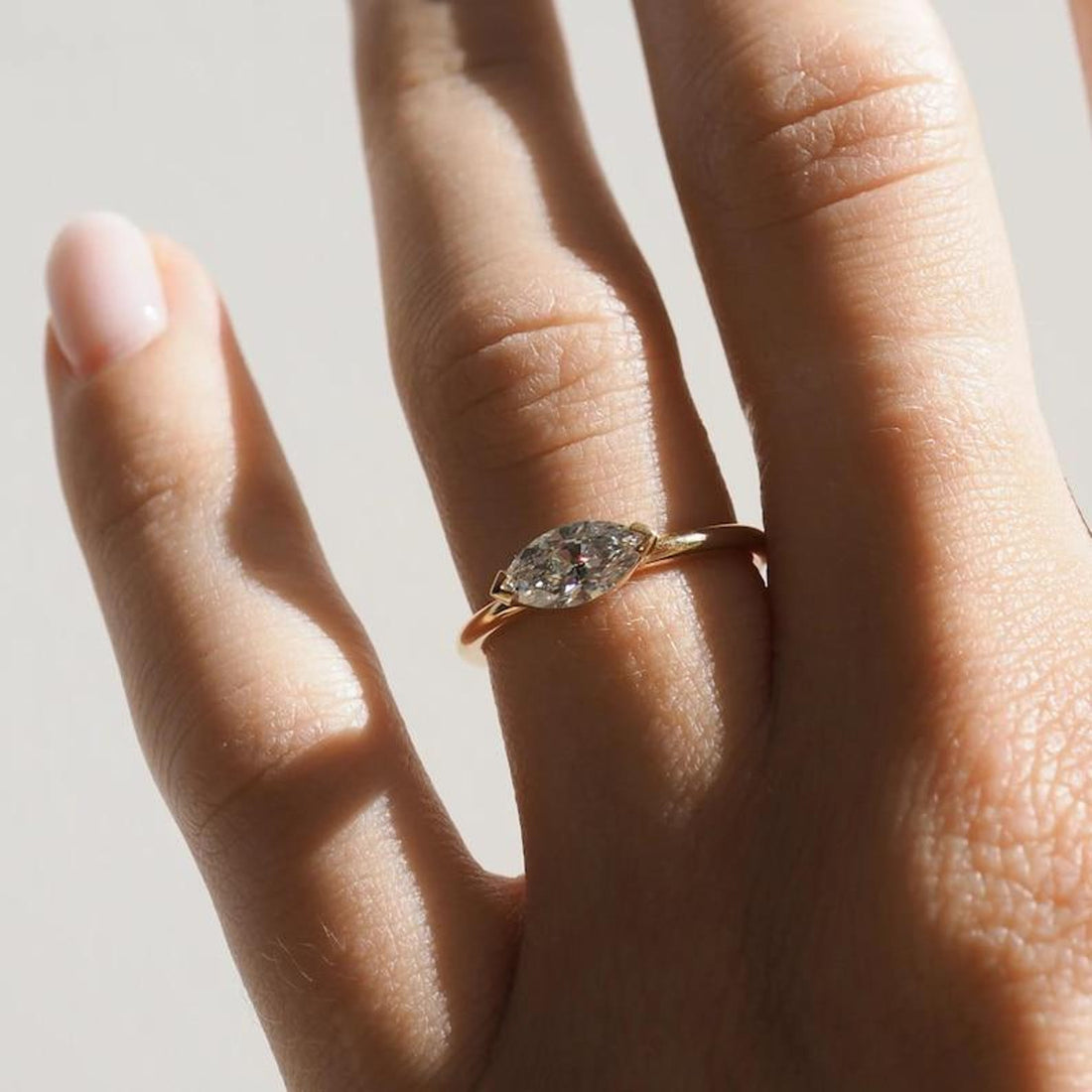 Elongated marquise cut lab grown diamond bezel set engagement ring
