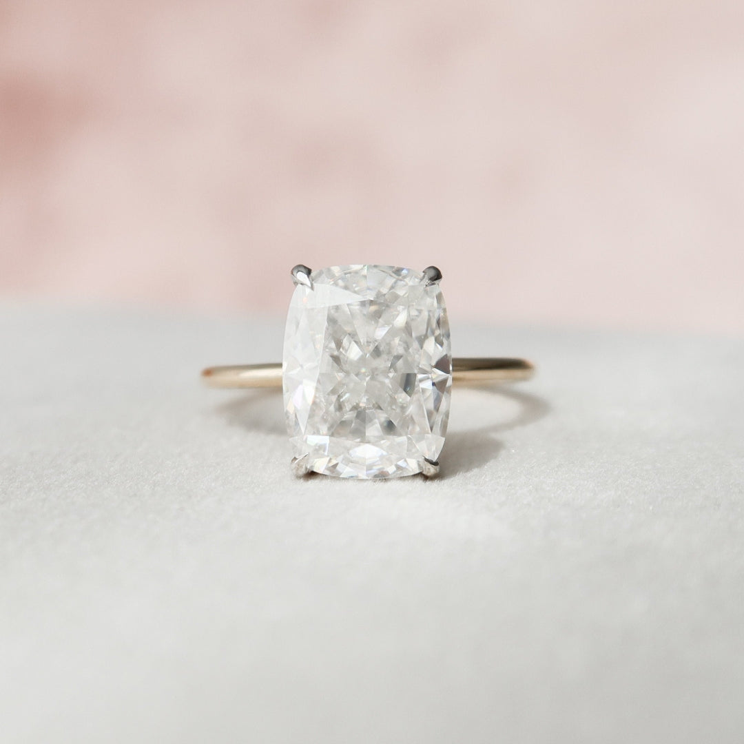 Elongated cushion cut lab grown diamond solitaire with a white gold head on a gold band