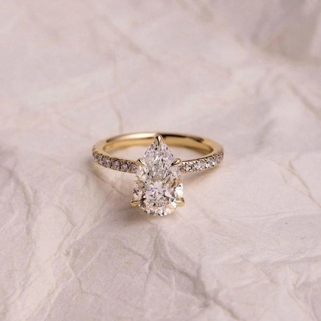 Pear cut lab grown diamond engagement ring with pave band in yellow gold