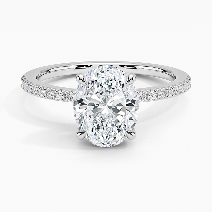Oval cut lab grown diamond ring with a hidden halo on a petite half pave band in white gold, top view