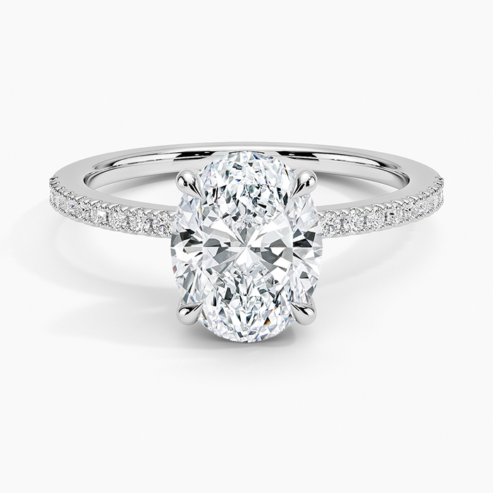 Oval cut lab grown diamond ring with a hidden halo on a petite half pave band in white gold, top view