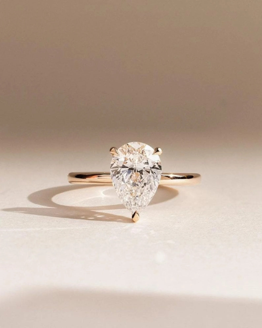 Pear cut lab grown diamond solitaire engagement ring on a plain rose gold band