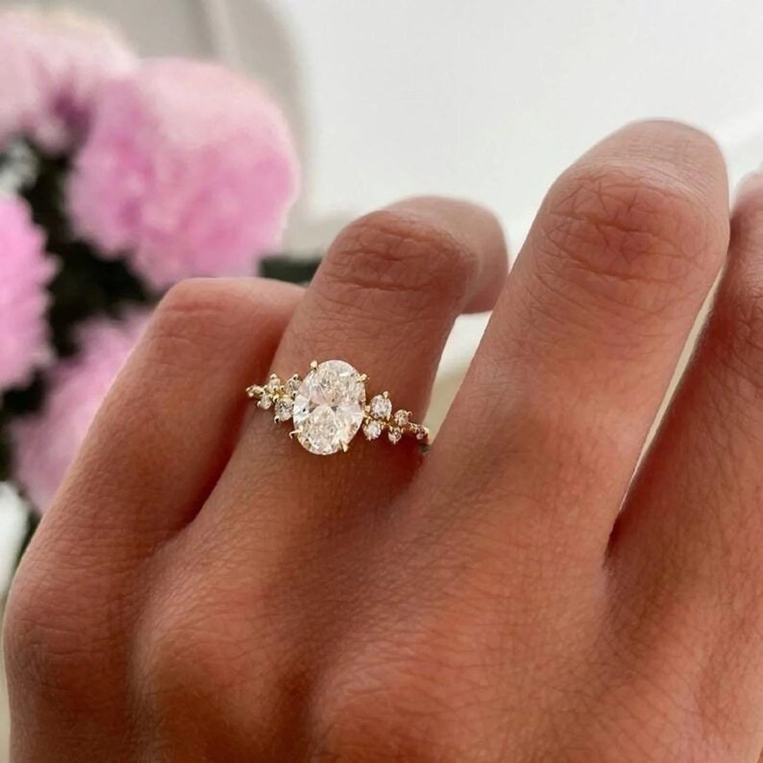 Oval cut lab grown diamond engagement ring with scattered cluster accents shown on the hand