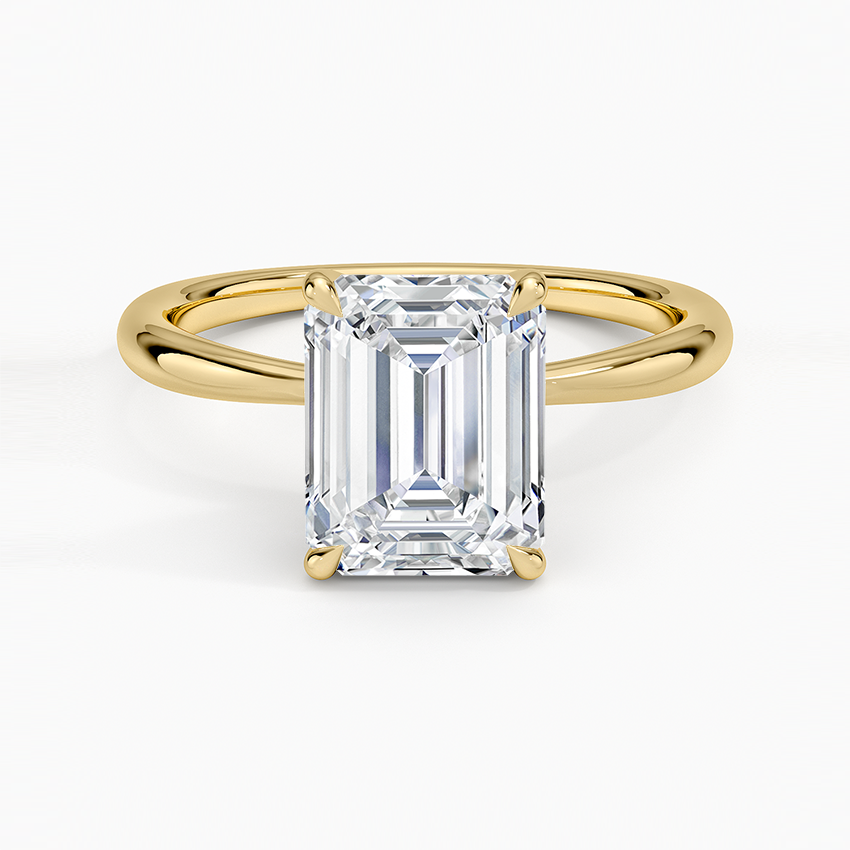 Emerald cut lab grown diamond ring in yellow gold on a plain crossover split shank band, top view