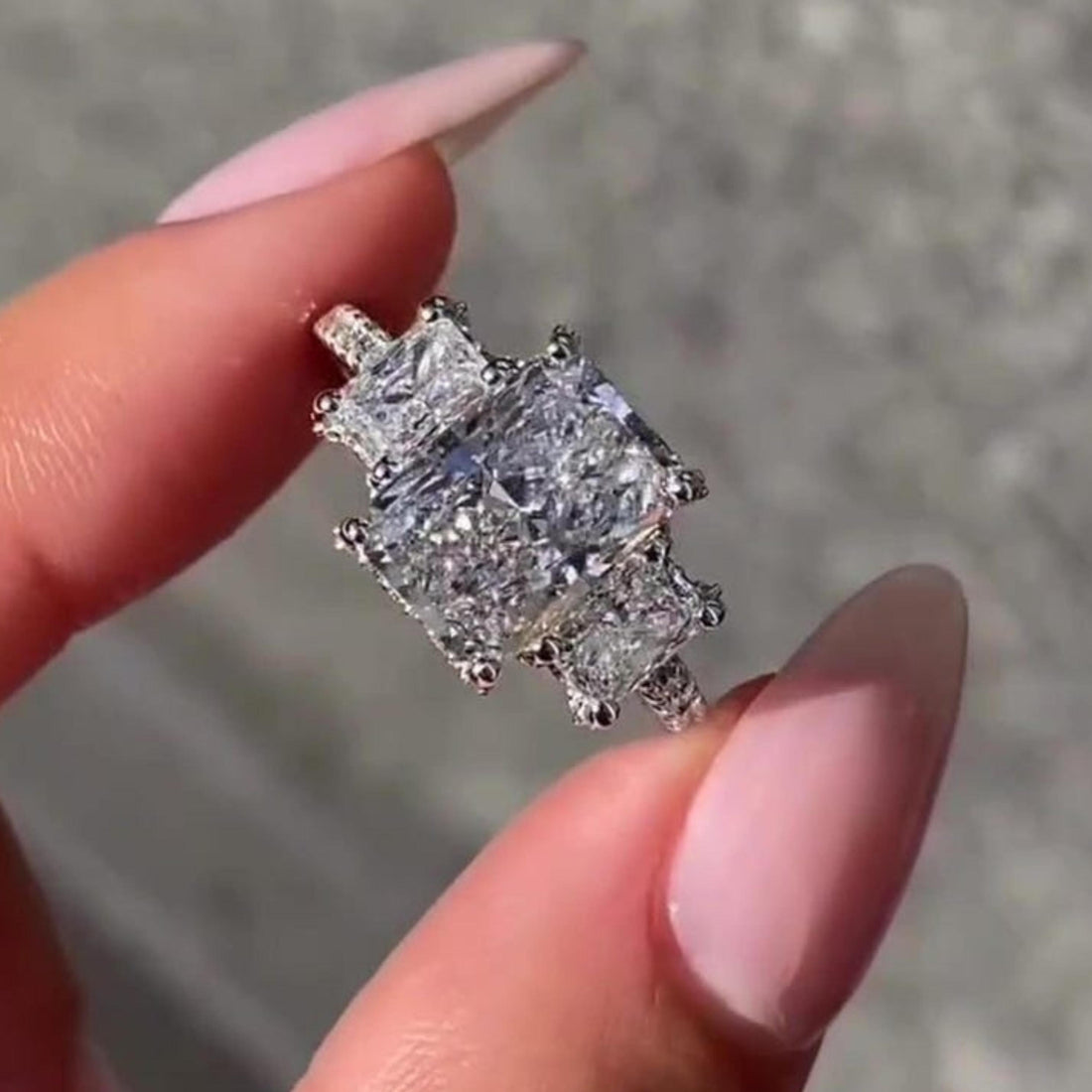 Radiant cut lab grown diamond three stone engagement ring with hidden halo and pave band