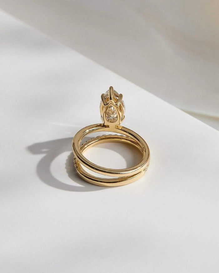 Pear cut solitaire engagement ring and matching pave band shown together