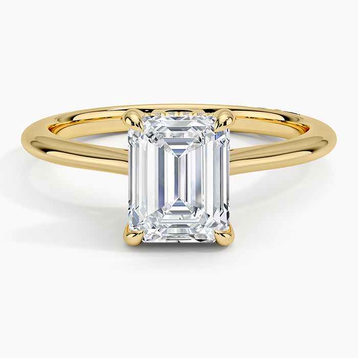 Emerald cut lab grown diamond ring with hidden halo and plain domed yellow gold band, top view