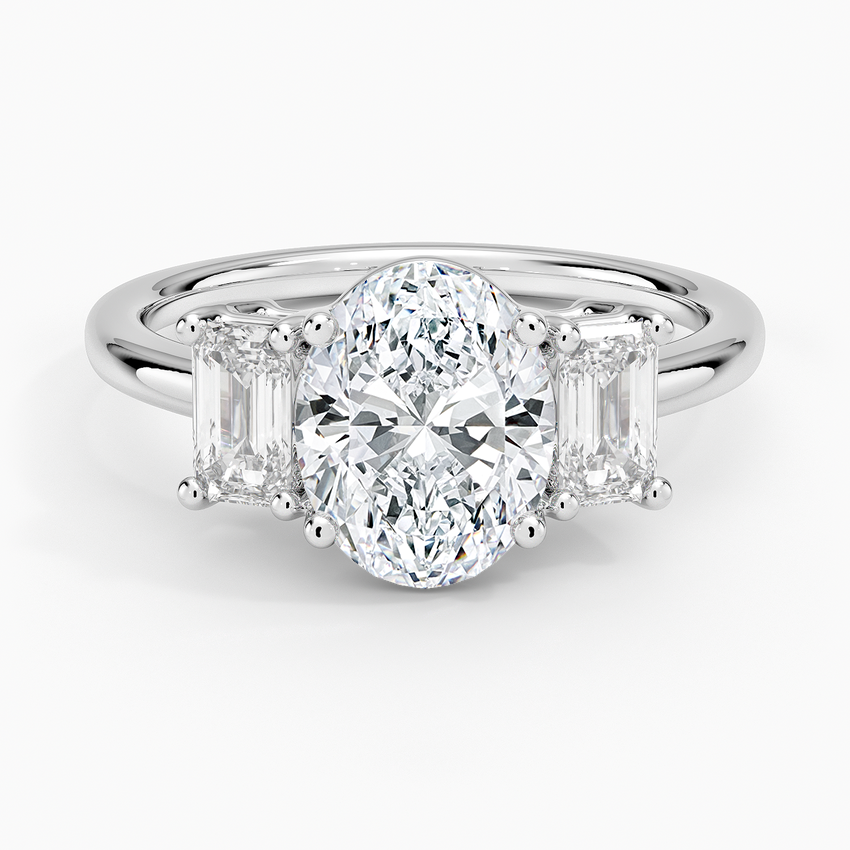 Oval cut lab grown diamond three stone ring with emerald cut side stones in white gold, top view
