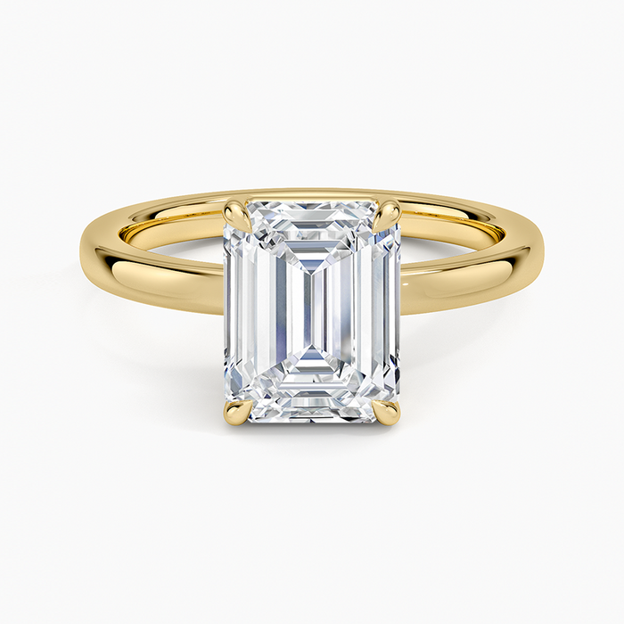 Emerald cut lab grown diamond solitaire ring in yellow gold with tapered half round band, top view