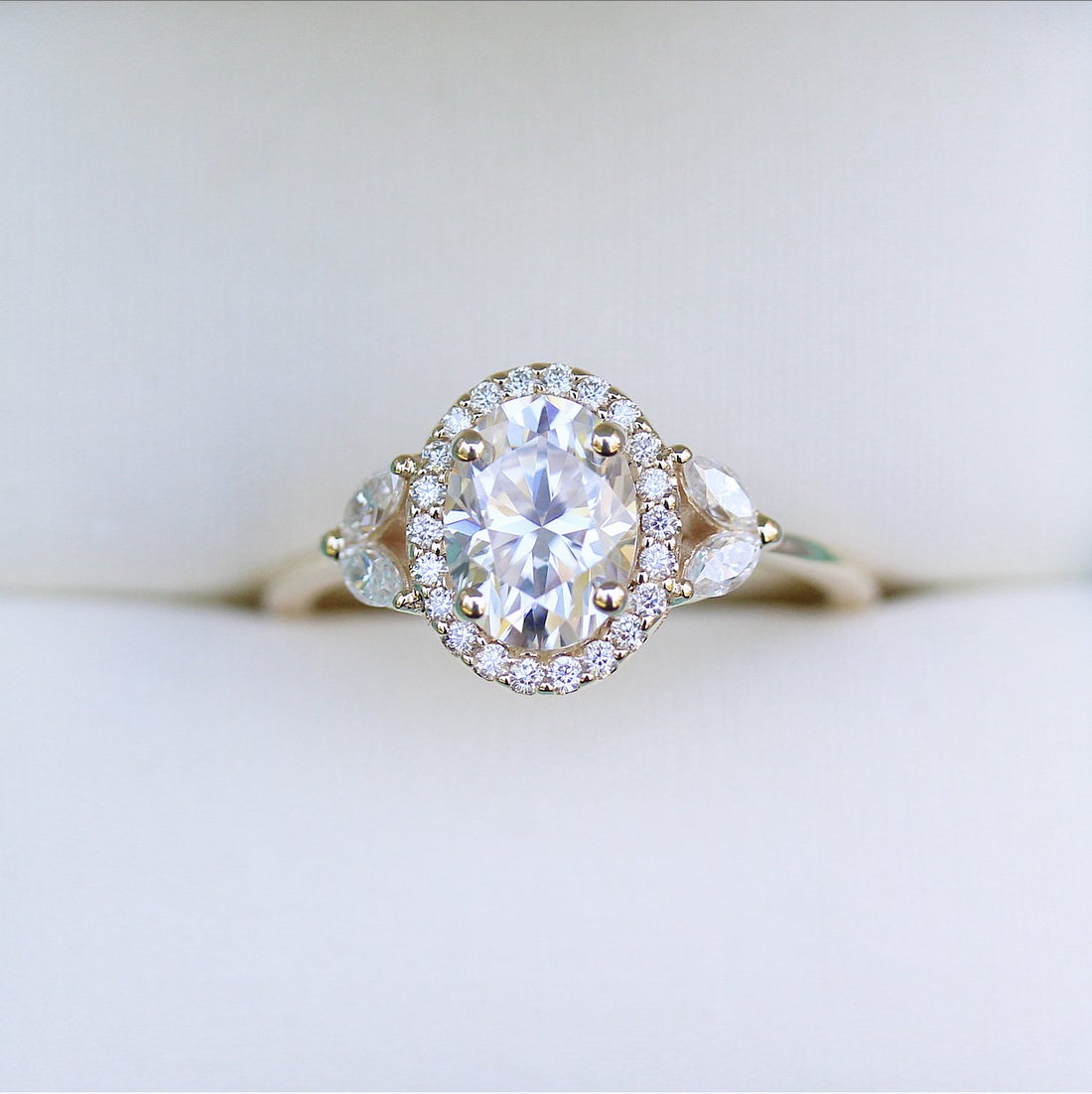 Oval lab grown diamond halo engagement ring with pear side stones