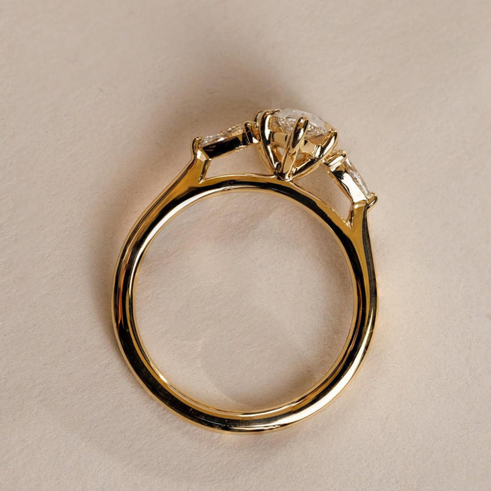 Pear cut lab grown diamond three stone trilogy ring with cathedral setting