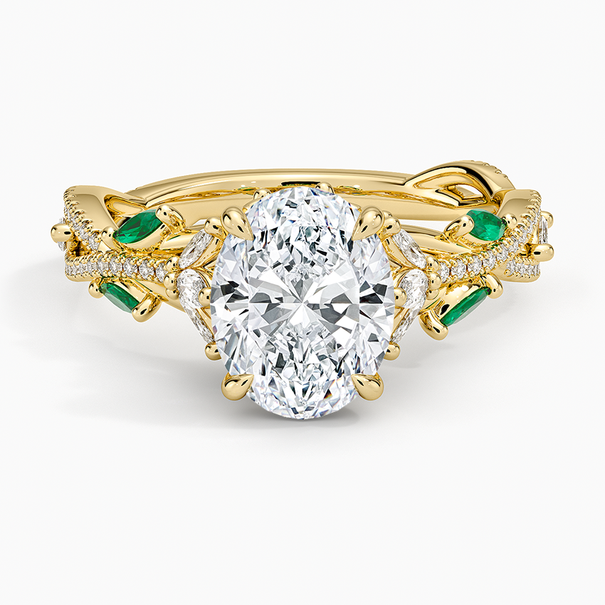 Oval cut lab grown diamond ring with lab emerald leaves on a pave vine band in yellow gold, top view