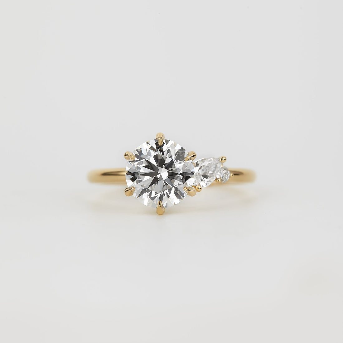 Round lab grown diamond three stone ring with marquise accents