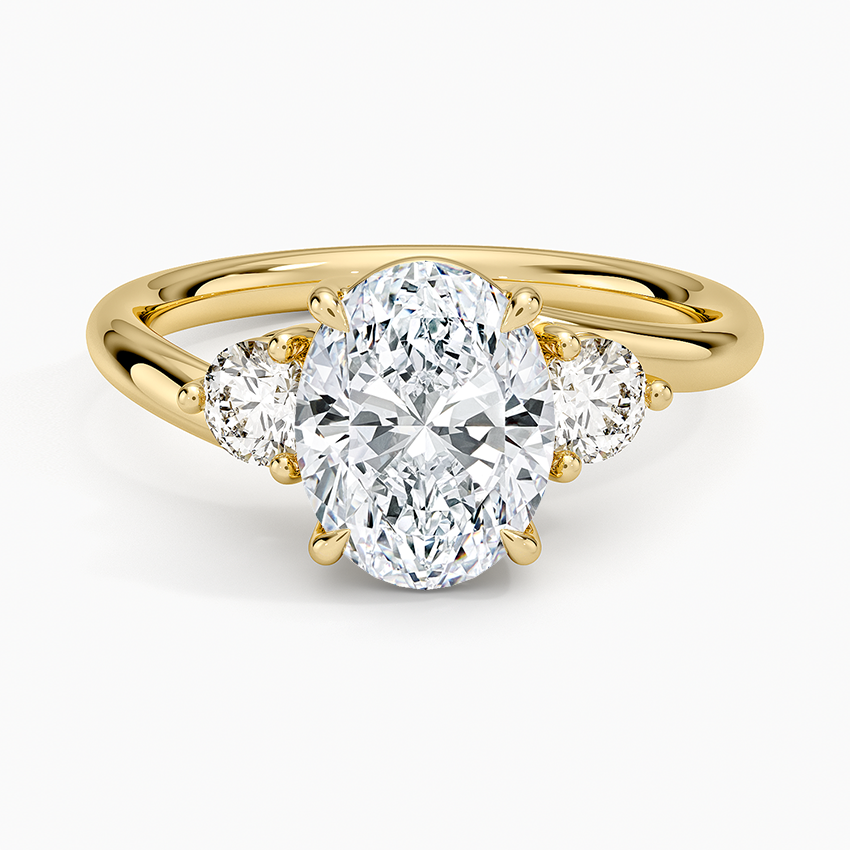 Oval cut lab grown diamond three stone ring with round side stones in yellow gold, top view